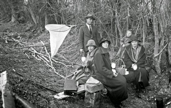 group having a picnic in bush beside the taieri river, with a whitebait net nearby, 1926